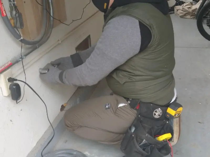 Electrician performing outlet wiring in a Montville garage
